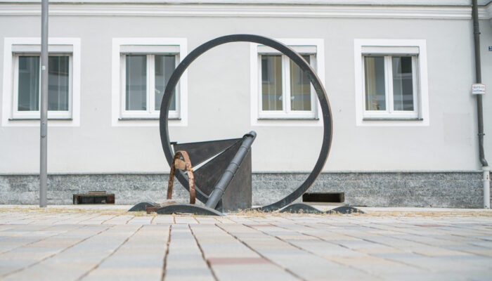 Kunstwerk „Wagenfragment - Goldene Straße“ des Bildhauers Heinrich Glas. Die Arbeit zeigt ein gebrochenes Radfragment nach einem Achsbruch, so wie er sich in früherer Zeit wohl des Öfteren auf der holprigen Goldenen Straße von Nürnberg nach Prag zugetragen haben dürfte.