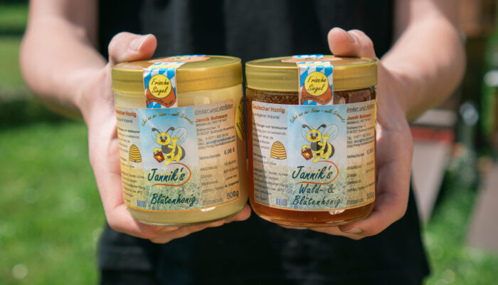 Detailaufnahme des fertigen Honigs in zwei Honiggläsern